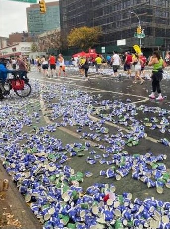 A marathon street covered in thousands of discarded water cups